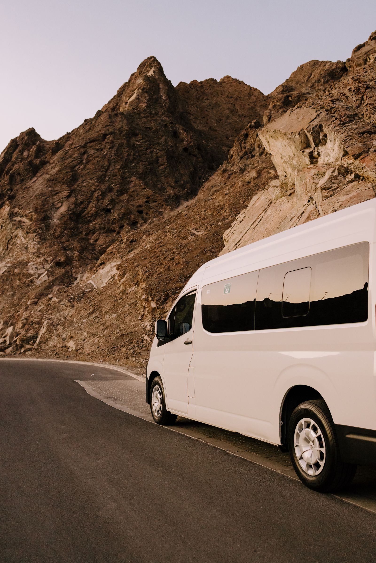 White high-roof van on a mountain road